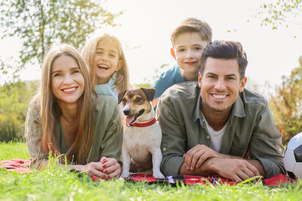 A family relaxing outdoors with their dog